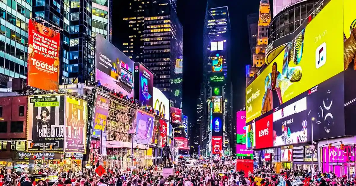 Vista aérea noturna de uma cidade com prédios iluminados, representando uma cidade inteligente.